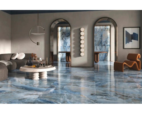 Wohnzimmer mit großformatigen glänzenden Bodenfliesen in Natursteinoptik und blauer Marmorierung in einem modernen, eleganten Interieur.
