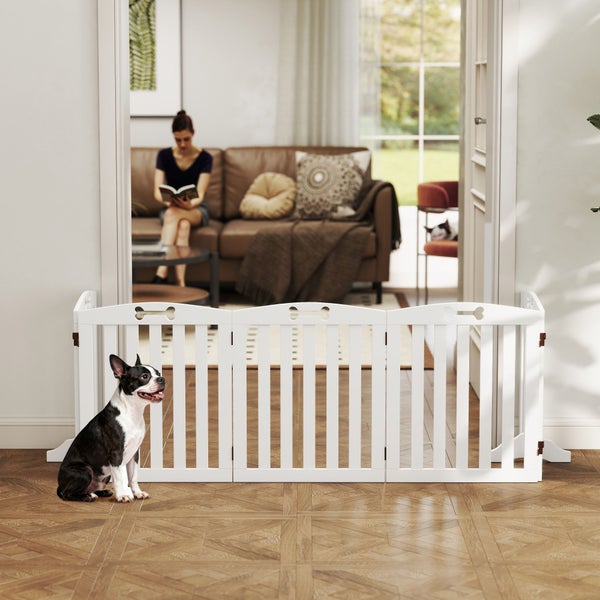 Weißes dreiteiliges Hundeabsperrgitter aus Holz in einem hellen Wohnzimmer mit einem kleinen Hund davor.