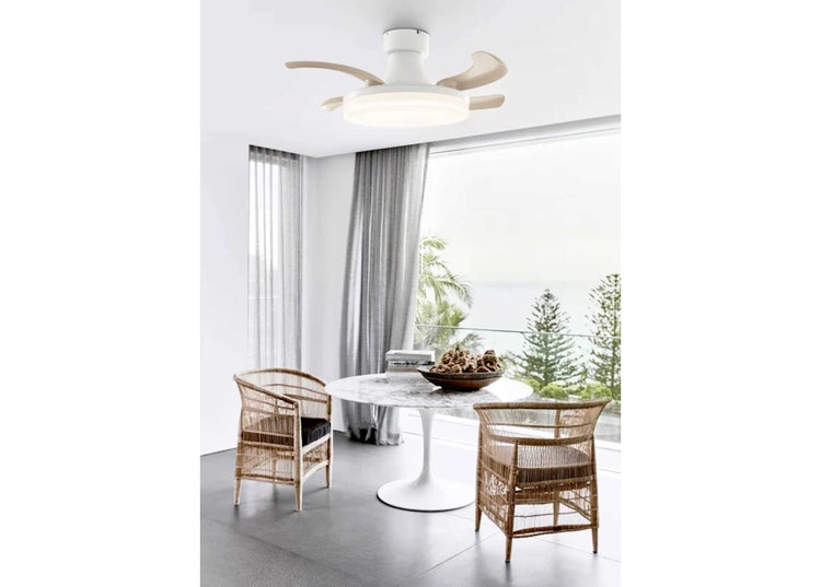 Deckenventilator mit integrierter LED Beleuchtung in einem hellen Esszimmer mit Rattanstühlen und einem runden Marmortisch am Fenster.
