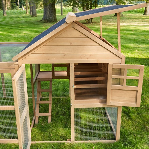Wetterfester Kleintierstall aus Holz mit Bitumendach im Garten und ein Kind auf dem Rasen.
