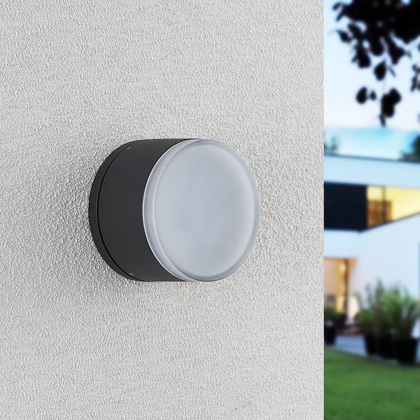 Runde Außenwandleuchte an einer strukturierten Fassade im modernen Design.