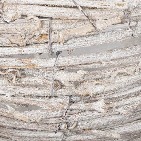 Detailansicht eines geflochtenen Weidenkranzes aus Zweigen mit weißer Patina als Dekoration.