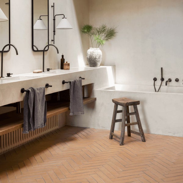 Modernes Badezimmer mit Doppelwaschtisch, Badewanne, Armaturen in Schwarz, Holzregal und Fliesenboden in Fischgrätoptik.