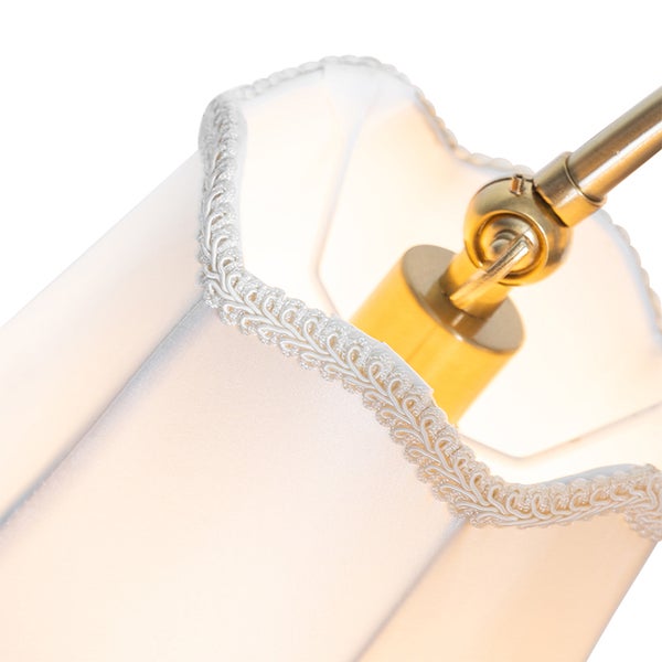 Detailansicht eines Lampenschirms aus Textil mit Zierborte und verstellbarem Gelenk aus Metall.
