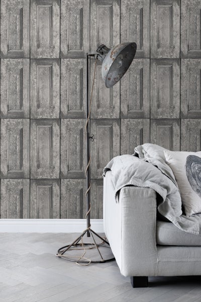 Wohnzimmer mit grauer Türpaneeltapete, Stehlampe und Sofa