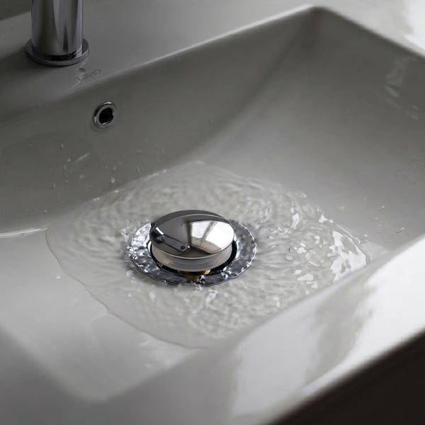 Pop-up Ablaufventil aus Metall in einem weißen Waschbecken mit fließendem Wasser. Lavio Logo.