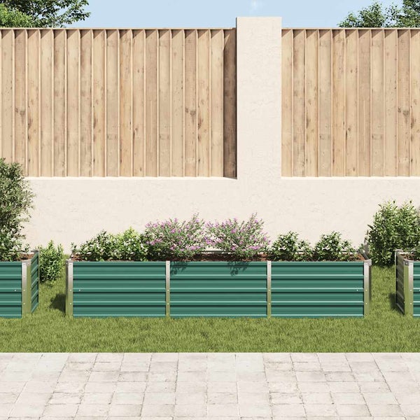 Hochbeet aus Metall mit Wellblechprofil im Garten vor einer hellen Mauer und einem Holzzaun.