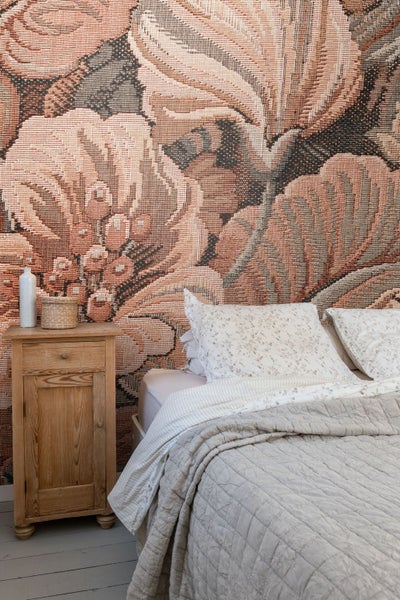 Schlafzimmer mit floraler Tapete, Bett und Nachttisch