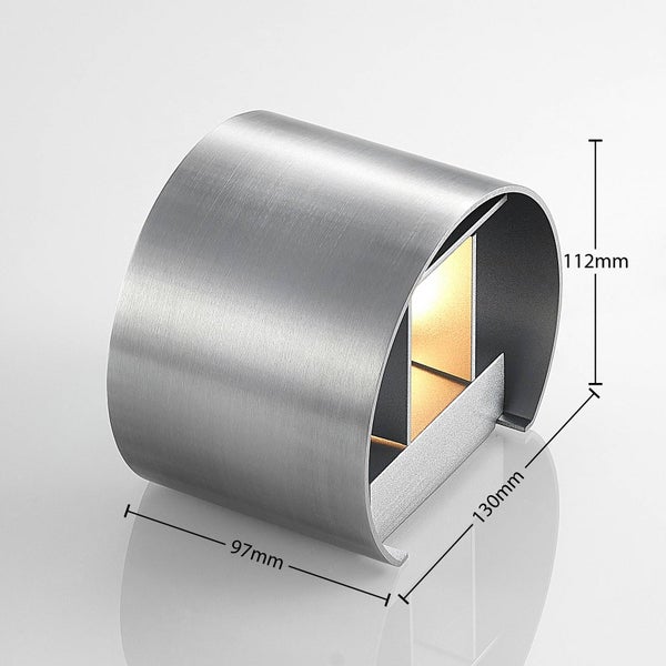 Halbrunde Wandleuchte aus gebürstetem Metall an einer strukturierten Wand mit verschiedenen einstellbaren Lichtkegeln nach oben und unten.