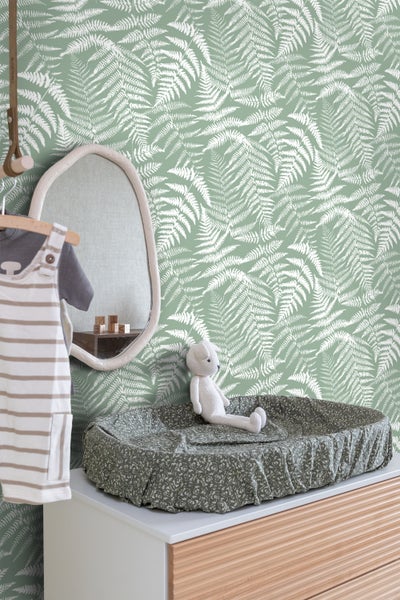 Kinderzimmer mit Wickelkommode, Spiegel und Tapete mit Farnmuster