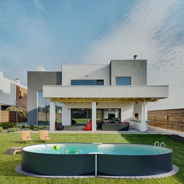 Modernes Haus mit Pool, Gartenmöbeln und gepflegtem Rasen