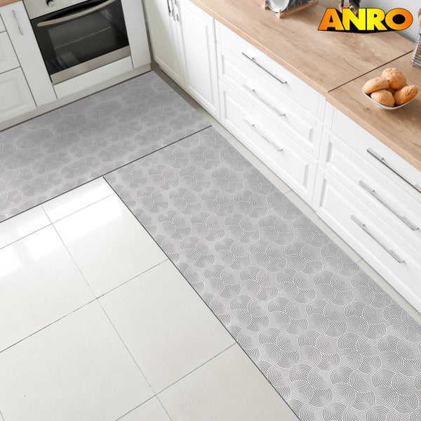 Küchenszene mit zwei Küchenläufern mit Muster vor weißen Küchenschränken