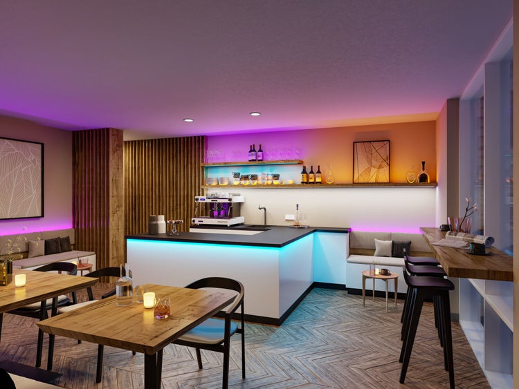Moderner Bar- und Cafébereich mit atmosphärischer LED-Beleuchtung, Holztischen, Stühlen und einem Parkettboden im Fischgrätmuster.