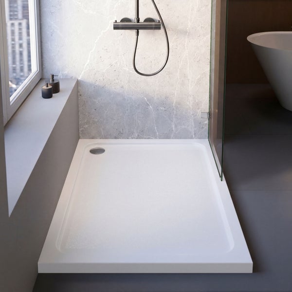 Rechteckige flache Duschwanne in einem modernen Badezimmer mit Wandfliesen in Marmoroptik und einer Glaswand.