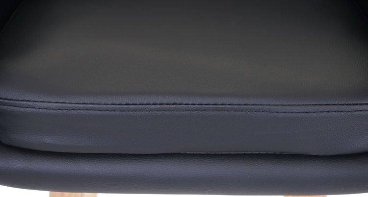 Detailaufnahme eines schwarzen Kunstledersitzes mit Naht