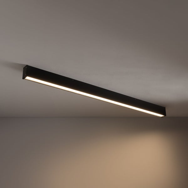 Schwarze LED-Deckenleuchte in länglicher Balkenform, warmweißes Licht, an der Decke montiert.