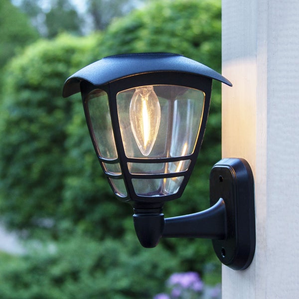 Dekorative Papiersterne in verschiedenen Farben hängen über einem Tisch mit Tischdecke und Vasen.