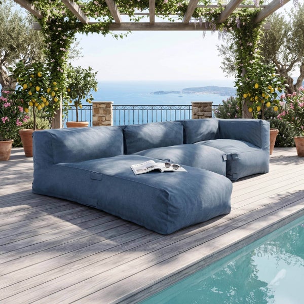 Blaues modulares Outdoor-Lounge-Sofa auf einer Holzterrasse am Pool unter einer Pergola mit Meerblick.