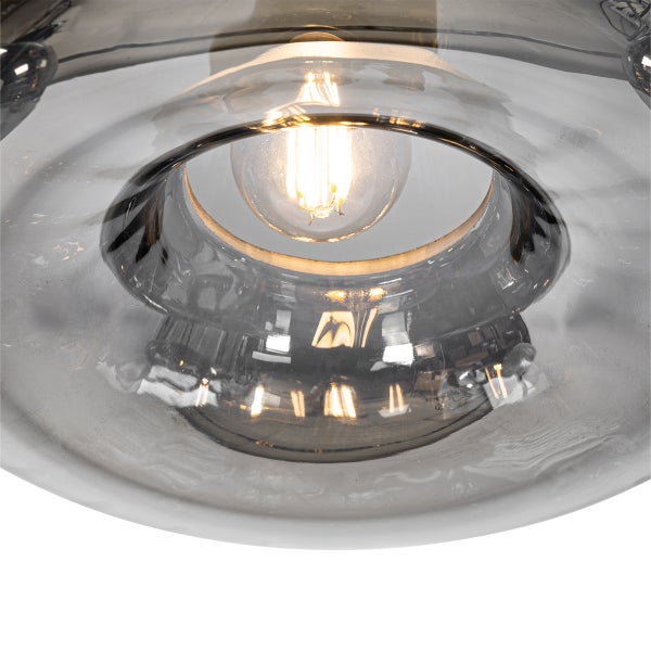 Detailaufnahme einer grauen Glasleuchte mit eingeschalteter Glühbirne