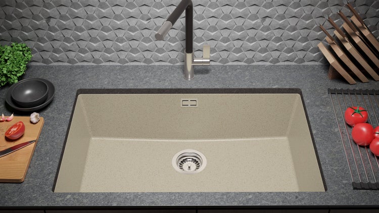 Küchenspüle aus Granit mit Abtropffläche, Spültischarmatur und Lebensmitteln auf der Arbeitsfläche.