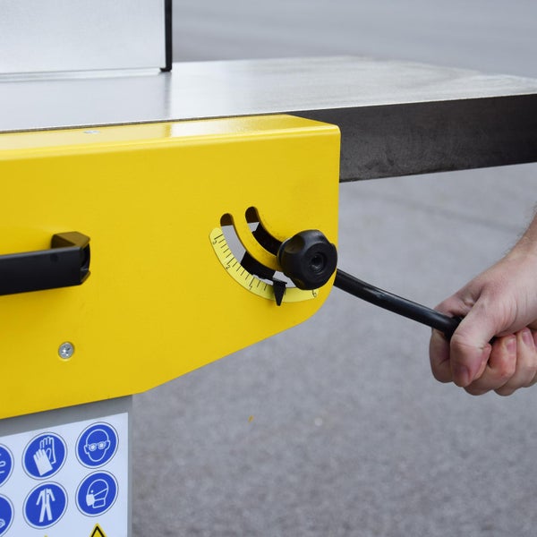 Detailansicht einer Bandsäge mit Bedienfeld und Hinweisschildern