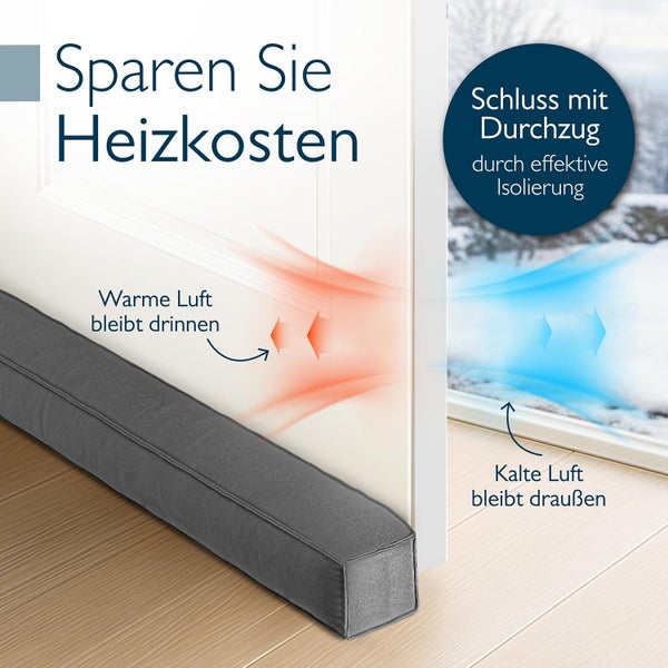 Grauer Zugluftstopper aus Stoff vor einer weißen Tür zur Isolierung gegen Kälte und zur Einsparung von Heizkosten.