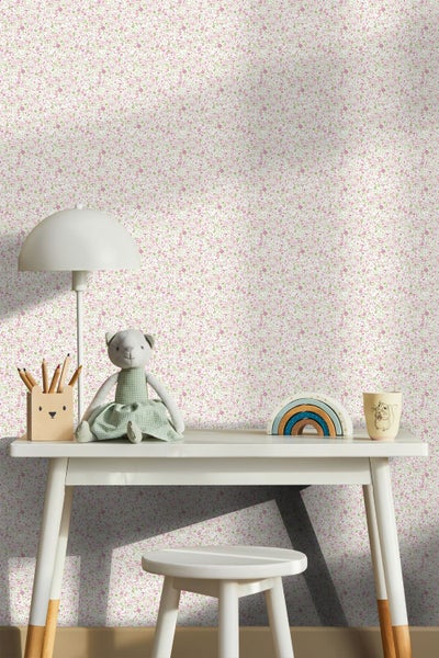 Kinderschreibtisch vor einer Wand mit Blumentapete mit kleinen rosa und grünen Blüten, helles und organisiertes Kinderzimmer.