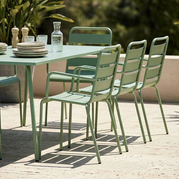Modernes Garten-Essset aus Metall mit einem rechteckigen Tisch und mehreren Armlehnstühlen mit Lattenrücken auf einer hellen Terrasse.