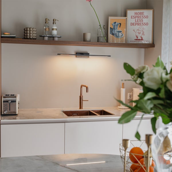 Küchenszene mit Spüle, Armatur, Küchenutensilien und Dekorationen