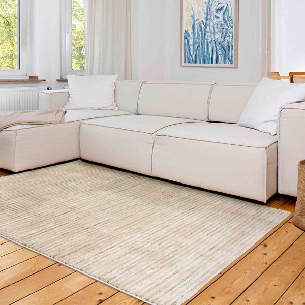 Heller Wohnraum mit Sofa und gemustertem Teppich auf Holzboden