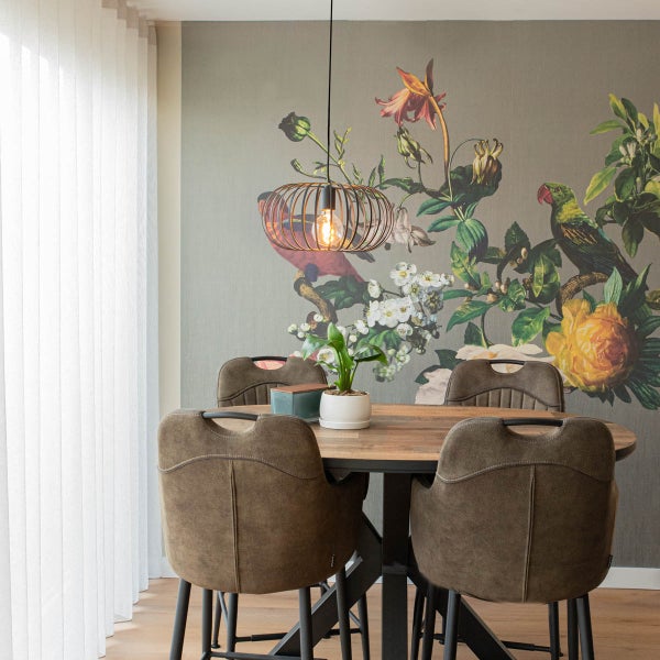 Esszimmer mit Esstisch, Stühlen und Pendelleuchte vor einer floralen Tapete