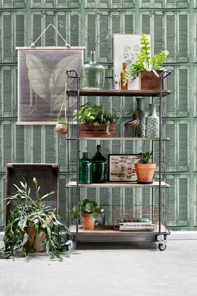 Dekoratives Regal mit Pflanzen, Vasen und Dekorationselementen vor einer gemusterten Wand.