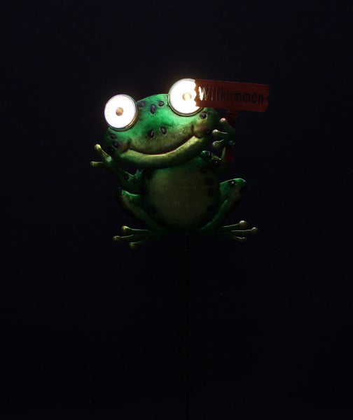 Solar-Gartenfigur Frosch mit leuchtenden Augen und Schild mit der Aufschrift Willkommen.