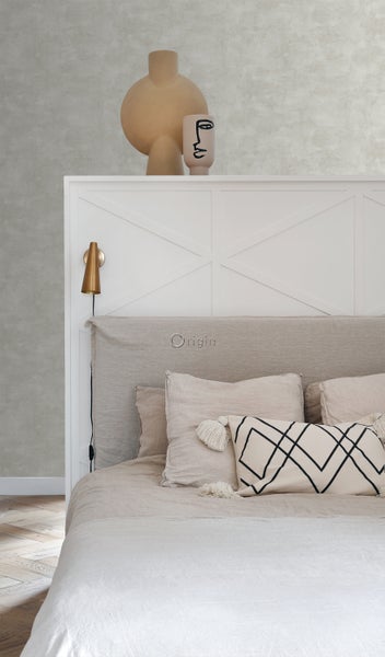 Schlafzimmer mit Bett, Kissen und dekorativen Vasen auf dem Kopfteil