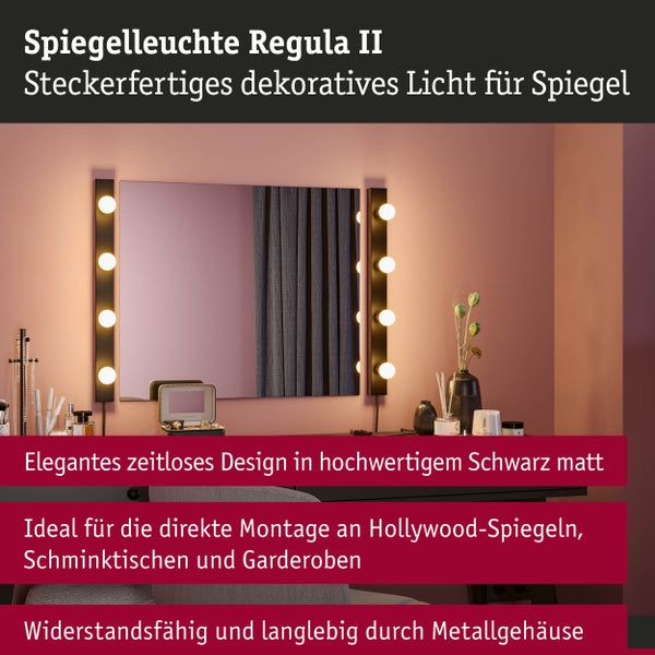 Zwei mattschwarze Spiegelleuchten Regula II im Hollywood-Stil neben einem rechteckigen Spiegel auf einem Frisiertisch montiert.