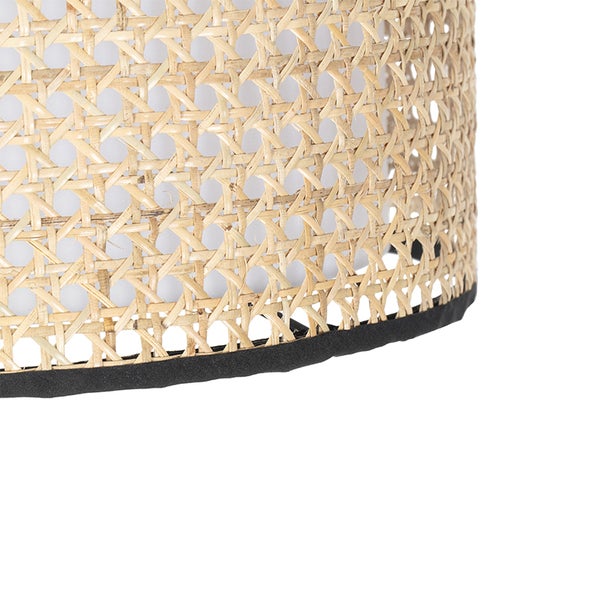Detail einer Lampe mit Rattanmuster und schwarzem Saum.