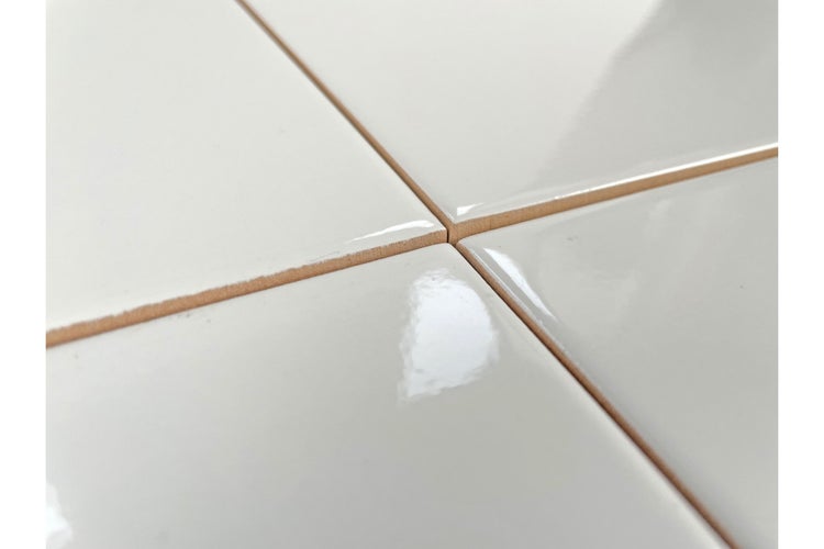 Nahaufnahme von weißen, glänzenden Keramikfliesen.