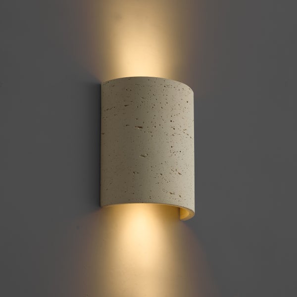 Moderne Wandleuchte aus Beton in halbrunder Form mit direktem Lichtaustritt nach oben und unten.