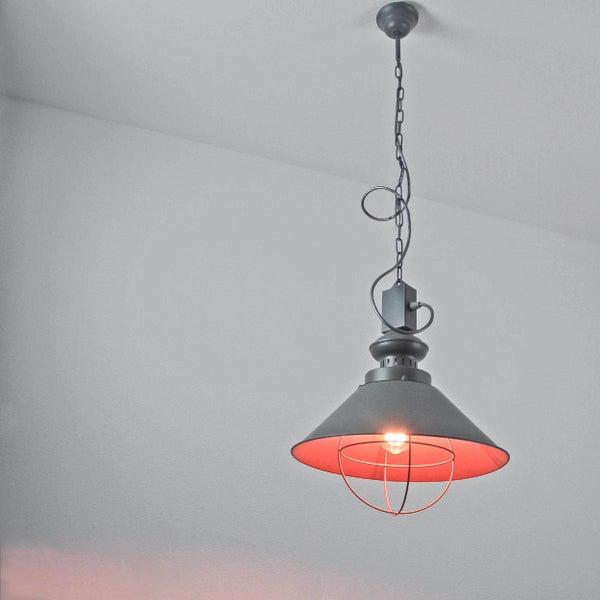 Industrielle Pendelleuchte aus dunklem Metall mit konischem Schirm, Schutzgitter und Kettenaufhängung.