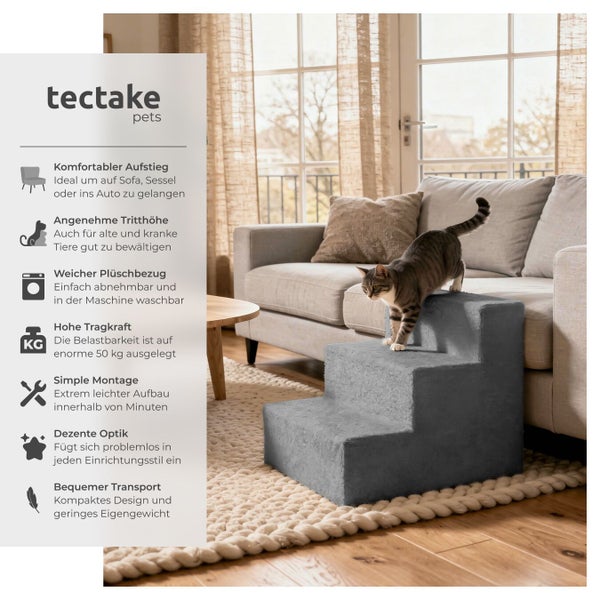 Graue Tierrampe mit drei Stufen und einer Katze, die darauf steht, neben einem Sofa.
