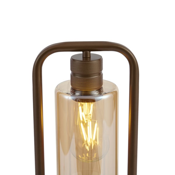 Dekorative Tischleuchte mit Glaszylinder und Metallrahmen.