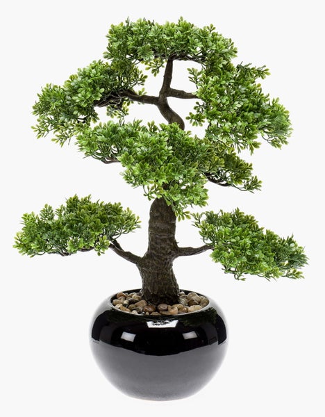 Künstlicher Bonsai Baum im runden, schwarzen Topf mit dekorativen Kieselsteinen.