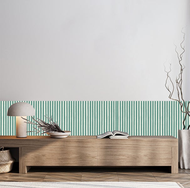 Wandgestaltung mit Tapete im Streifenmuster in Grün und Weiß über einer Holzkommode