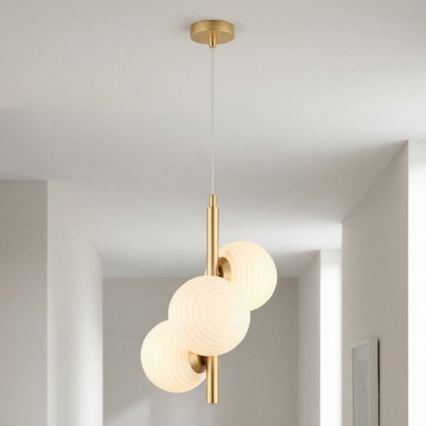 Dreiflammige Pendelleuchte mit goldfarbenem Metallstab und drei weißen Glaskugeln mit Rillenstruktur.
