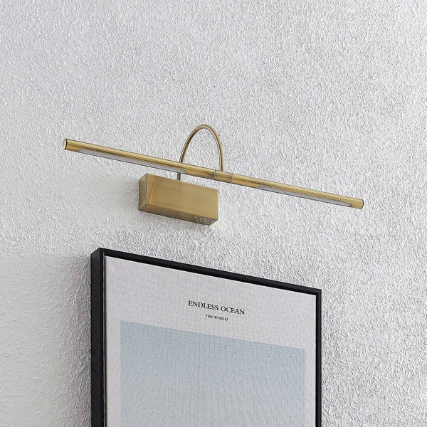 Horizontale messingfarbene Bilderleuchte aus Metall, montiert über einem Bild an einer strukturierten Wand.