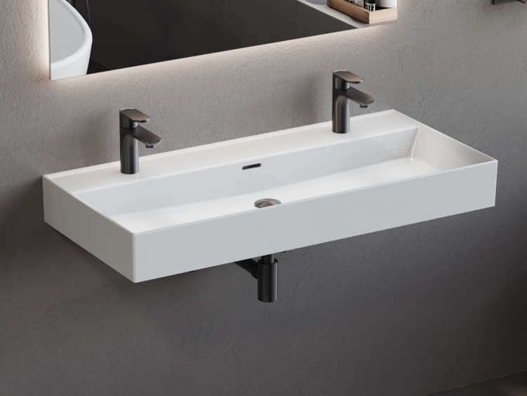 Modernes rechteckiges Doppelwaschbecken aus weißer Keramik mit zwei dunkelgrauen Armaturen, wandhängend in einem Badezimmer.