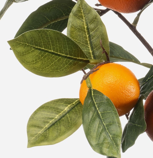 Detailansicht eines künstlichen Orangenbaums mit grünen Blättern und einer orangefarbenen Frucht.