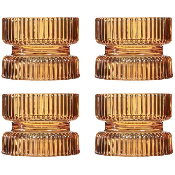 Vier Teelichthalter aus bernsteinfarbenem Glas mit geriffelter Struktur.