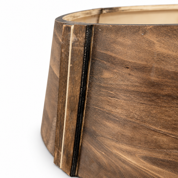 Detailansicht eines konischen Baumständerfußes aus Holz mit deutlicher Maserung und markanter Verbindungsleiste.