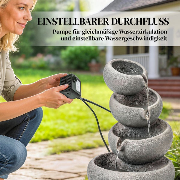 Etagenbrunnen in Steinoptik auf einer Terrasse mit warmweißer LED-Beleuchtung in den vier Schalen.